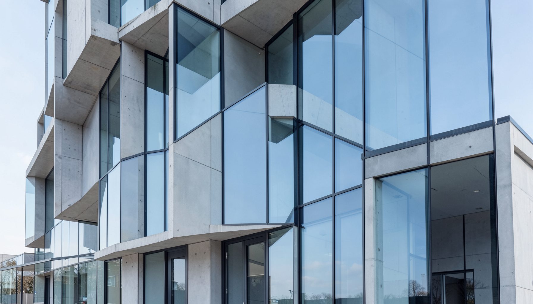 A modern building facade with clean geometric lines, glass and concrete surfaces in cool grey and sky-blue tones